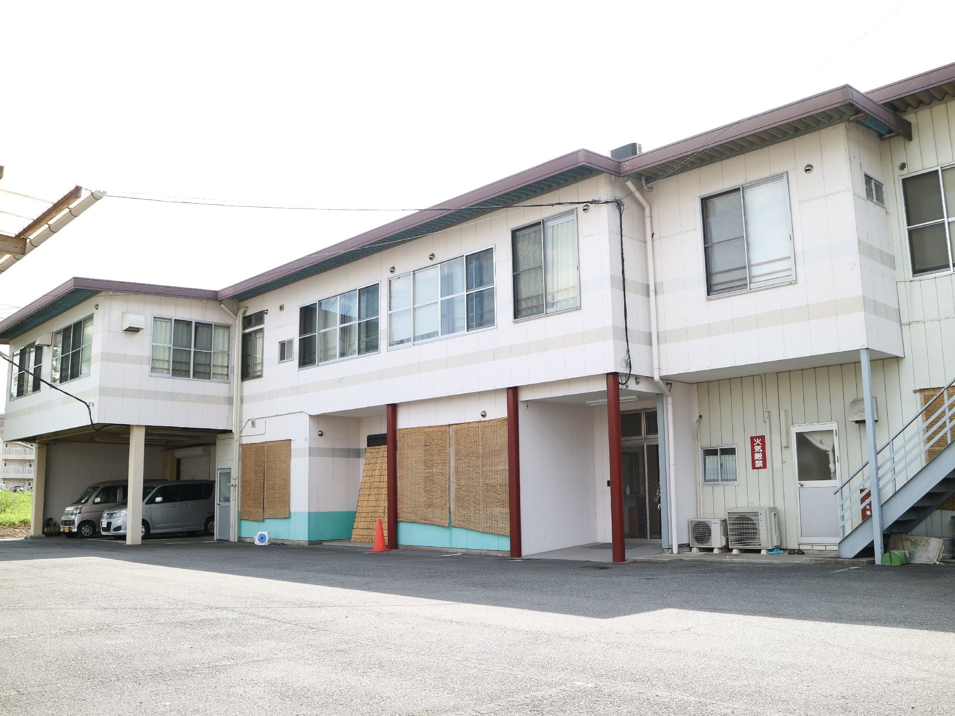 一階の一部が駐車場になっており、外階段が付いている二階建て施設
