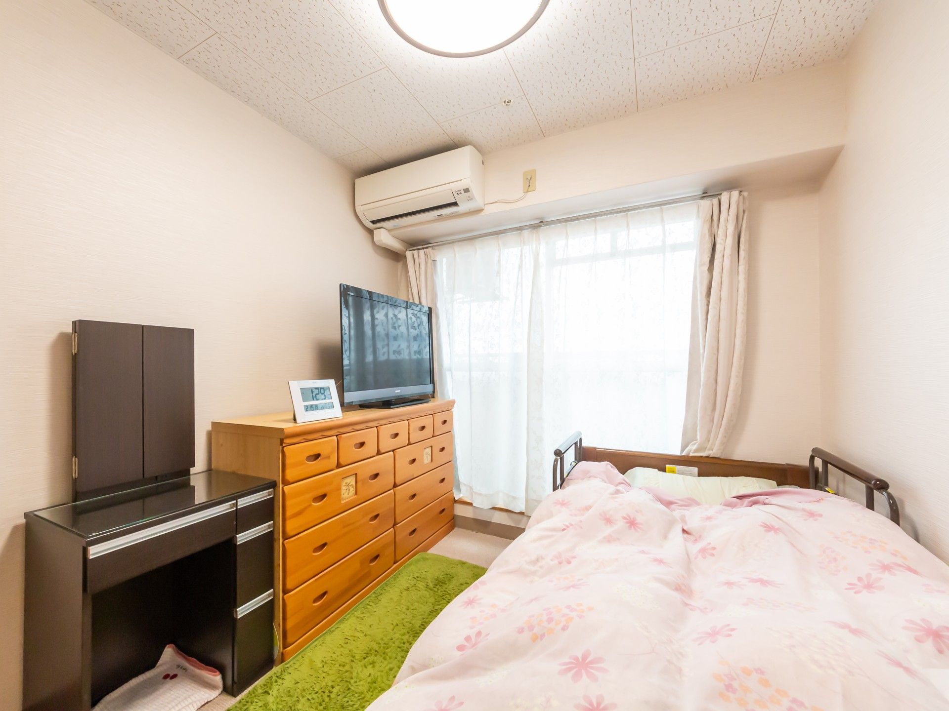 大きな窓とエアコンが取り付けられていて、家具のない居室