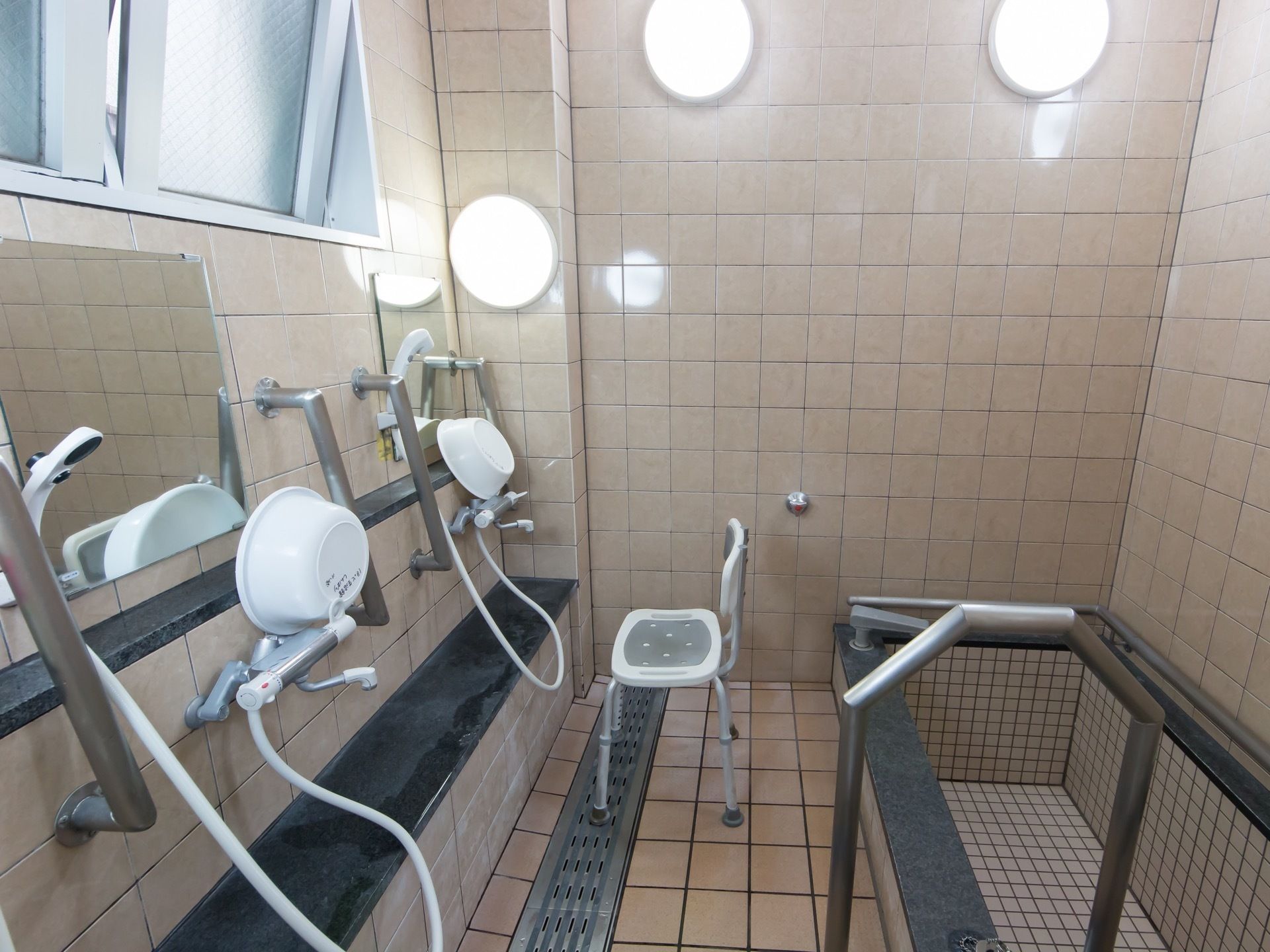 洗い場が並んでいる共同浴室がある。洗い場の後ろに掘り込み式の浴槽があり、太い手すりが付けられている