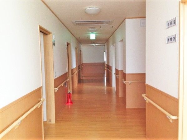 手すりが両サイドについた廊下。居室は引き戸で、日当たりも良好。