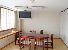 いすとテーブルがある共有スペース。大型のテレビがある