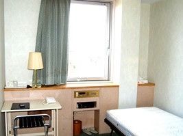 一人用の小さなワンルーム。ベッドと物が置けるテーブルが置いてある