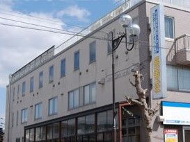 鉄骨造の建物の外観。シンプルな構造と柔らかい色合い