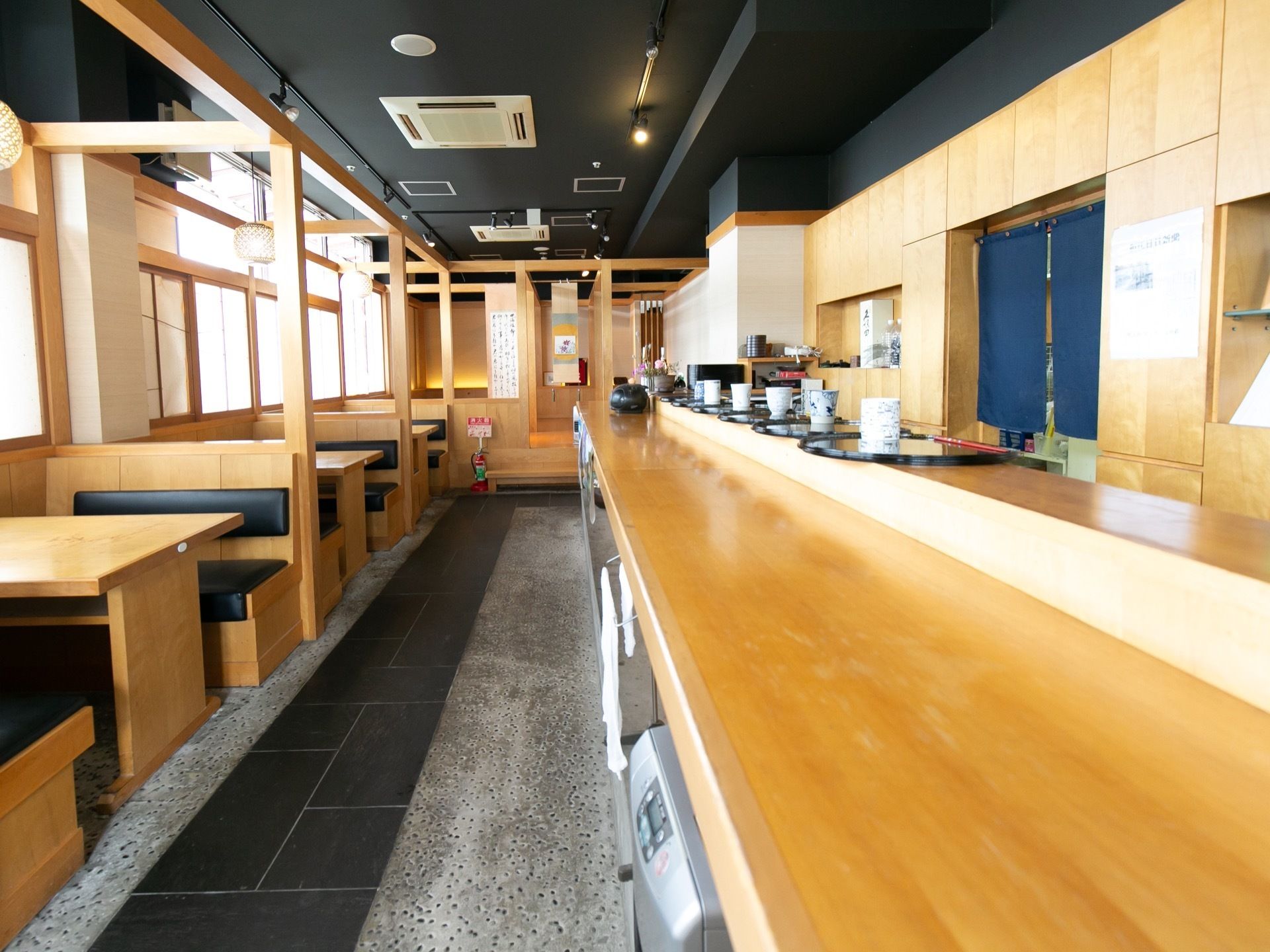 和風の居酒屋のような内装の食堂がある。木の素材をふんだんに使い、床には石が敷かれている。広いカウンターの奥には厨房がある。
