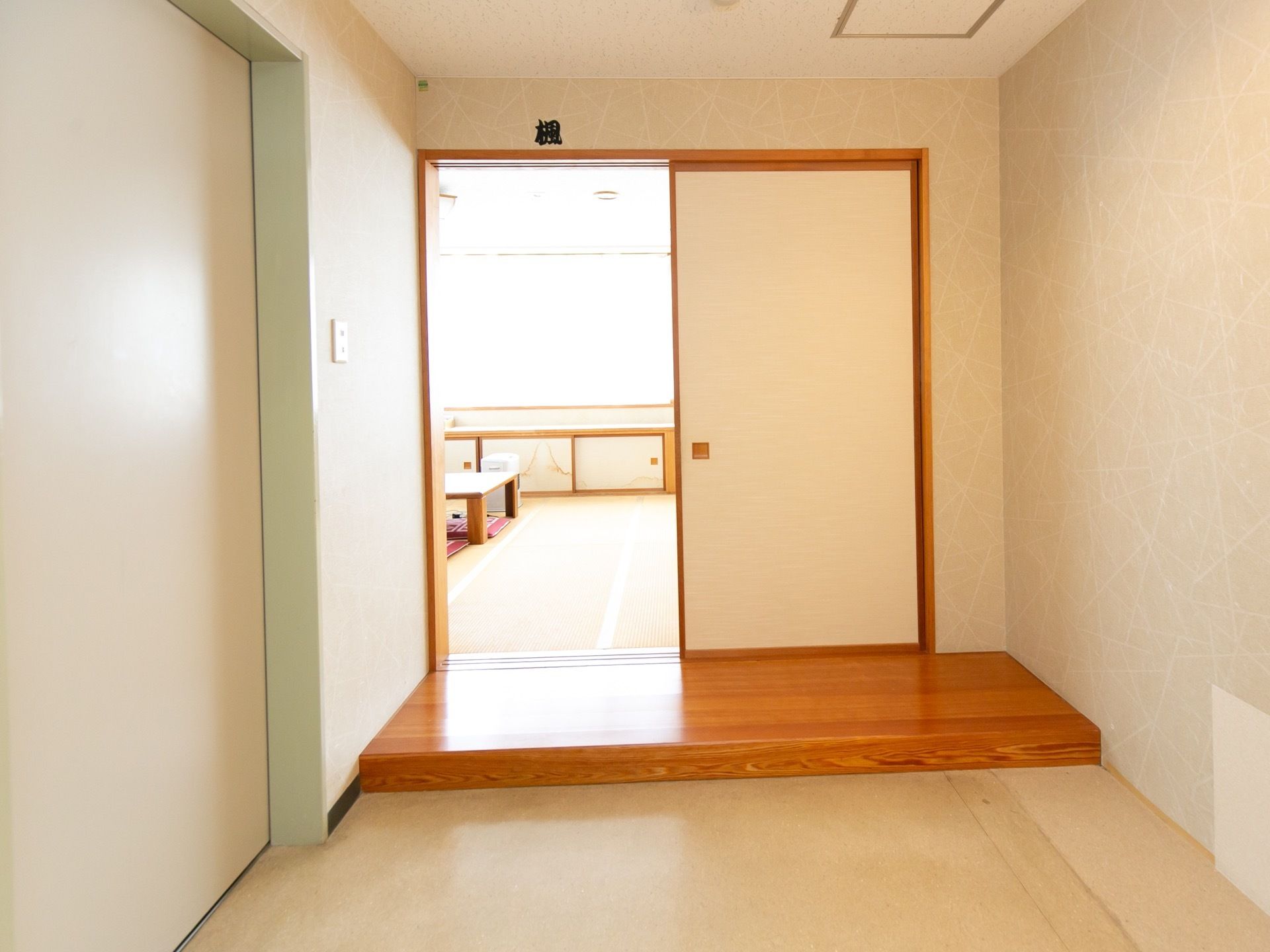 談話室へと続いている襖の扉がある。木製の上がりかまちがあり、内部は畳敷きの和風の内装。テーブルが置かれ、窓際には和風の棚がある。