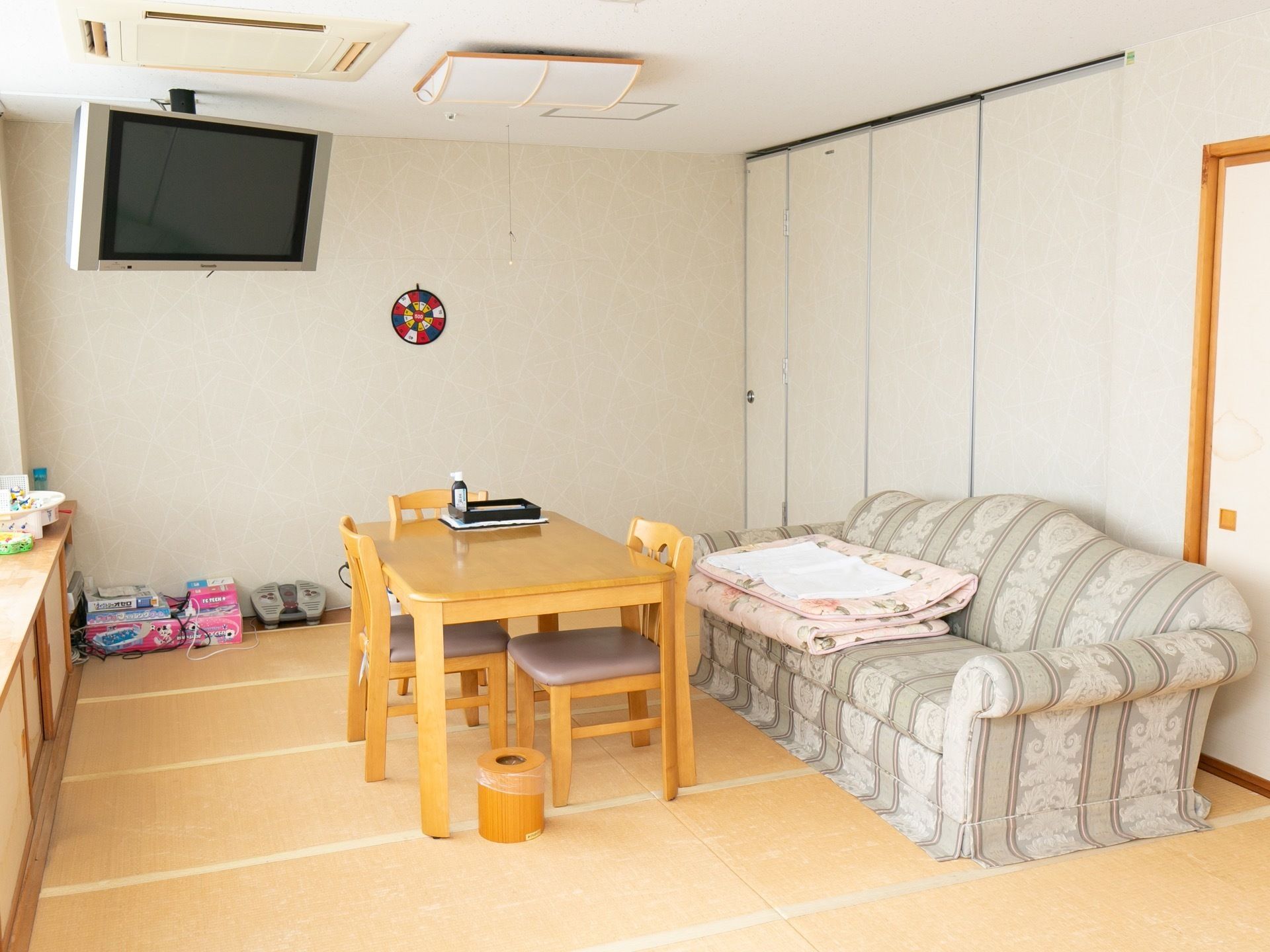 畳敷きの談話室がある。天井からテレビが掛かっている。大きなソファとテーブル、椅子が置かれている。窓際には背の低い備え付けの棚がある。