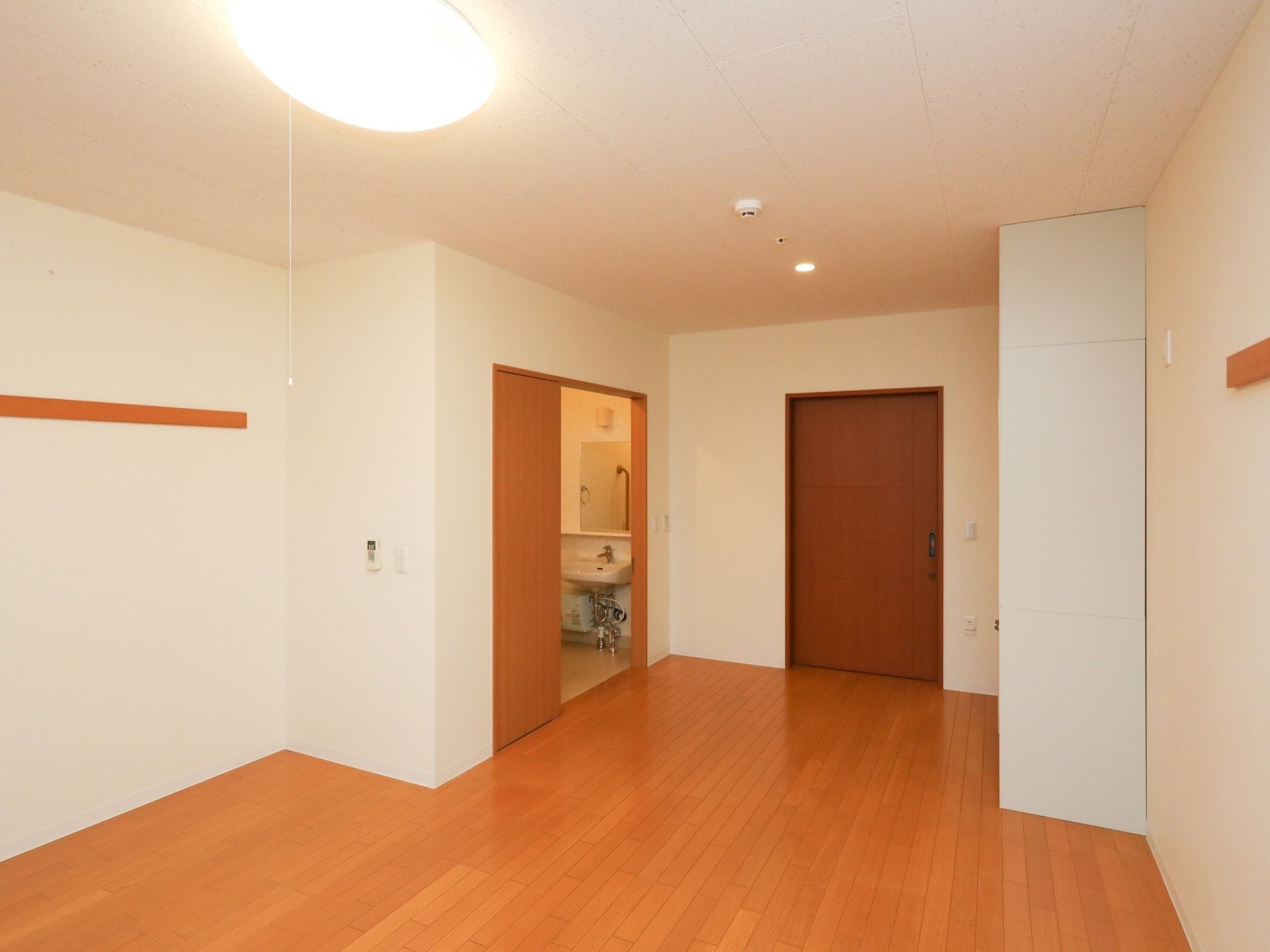 居室は、ナチュラル系の色の建具が使わており、温かみの感じられる洋室である。バリアフリー構造で、車椅子をご利用の方も生活していただきやすい。