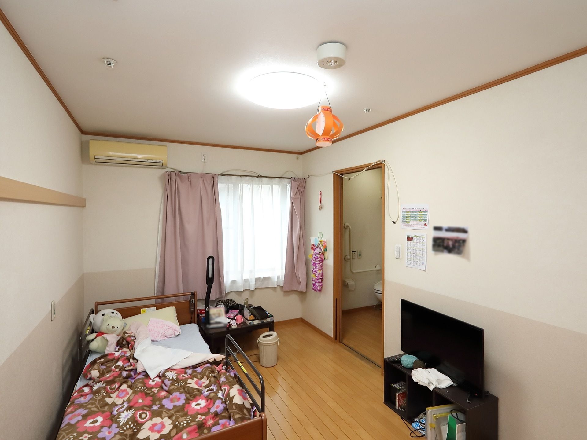 居室には窓があり、陽射しが差し込んでいる。ベッドには転落を防止する柵があるので、安心して眠ることができる。