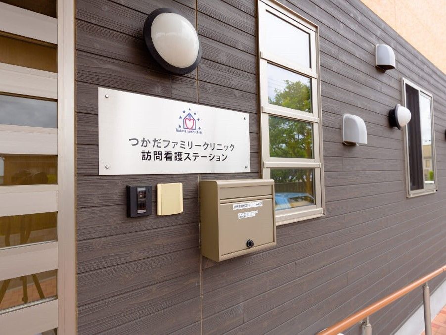 クリニックや訪問看護ステーションの名前が書かれたシルバーのプレートや郵便ポストが設置された建物。