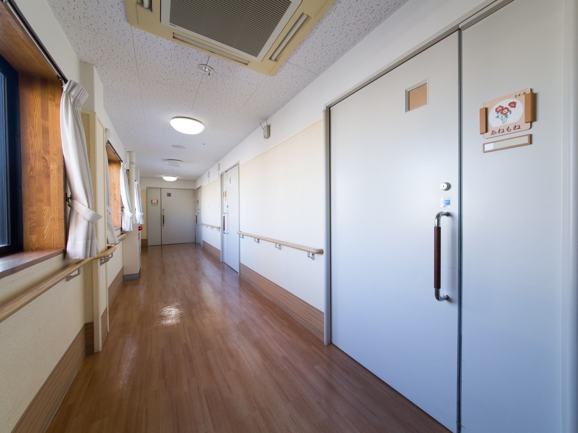 居室の扉には部屋の番号の他に、覚えやすいよう花の絵柄の札と名前、入居者様の氏名が飾られている。家族も覚えることができる。