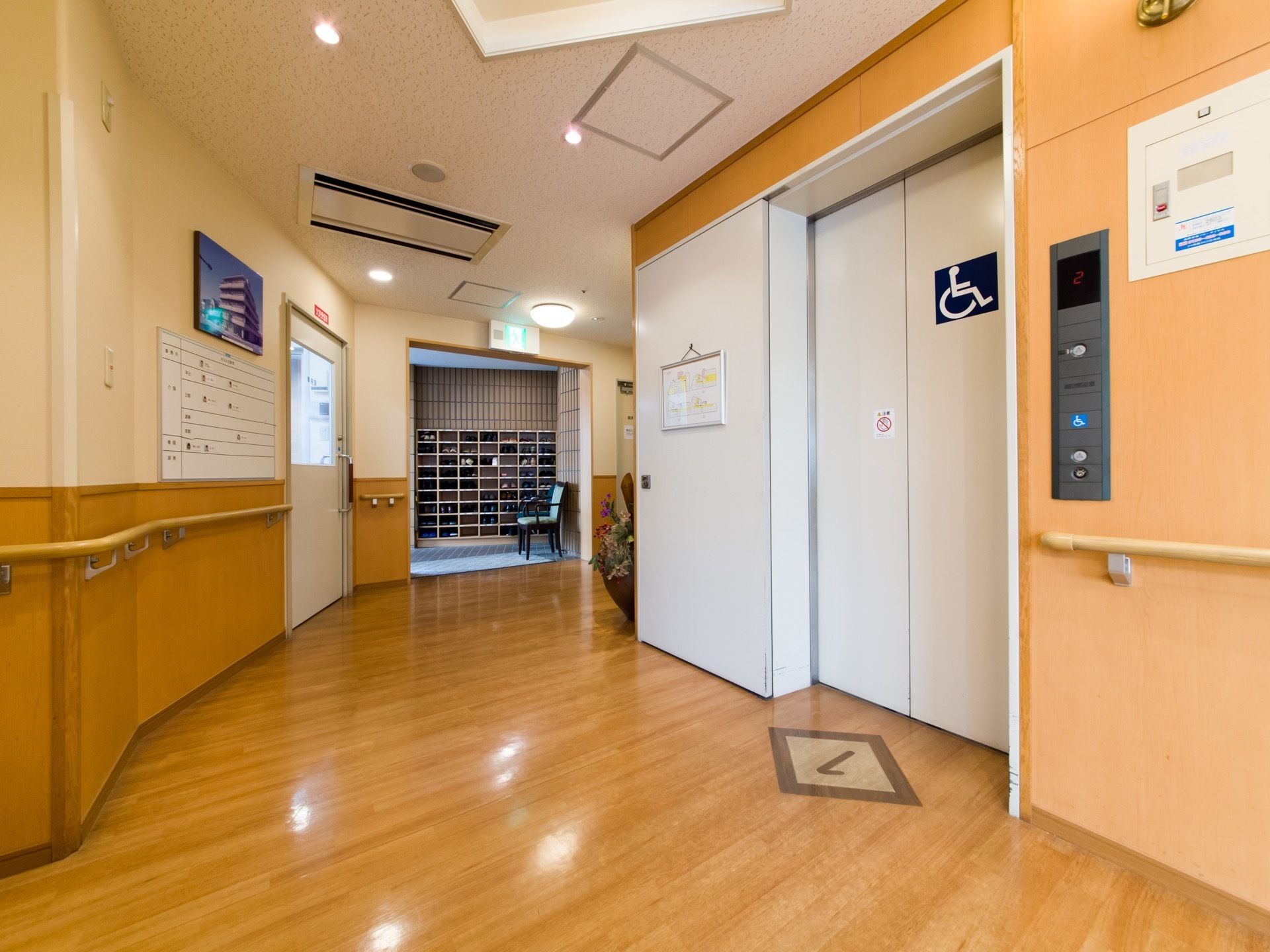玄関を入ってすぐの廊下の壁にスタッフ写真が飾ってある。当日の出勤を見学者や利用者様の家族が見ることができる。