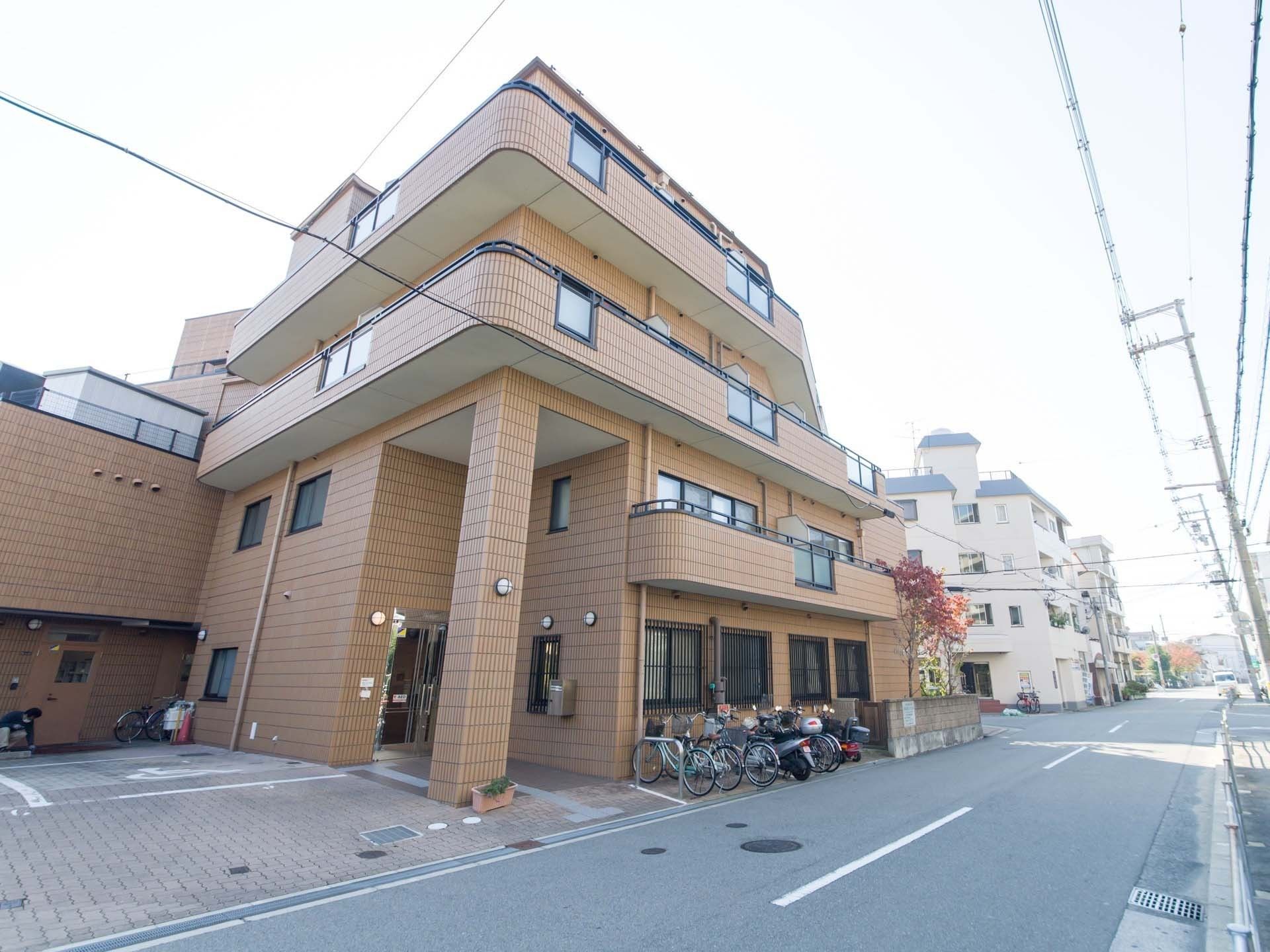 外壁はオレンジのレンガ調で落ち着いた雰囲気の施設になっている。周辺の環境と馴染んでいる。看板が取り付けられている。