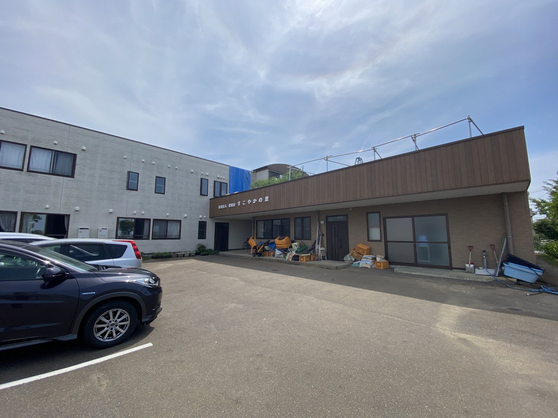 白ウィ２階建ての建物は日当たり良好でブラウンの外壁の平屋建ての建物が併設されている。