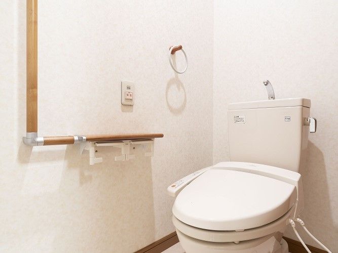 居室内の明るいトイレ。温水洗浄機器がついており、清潔感がある。