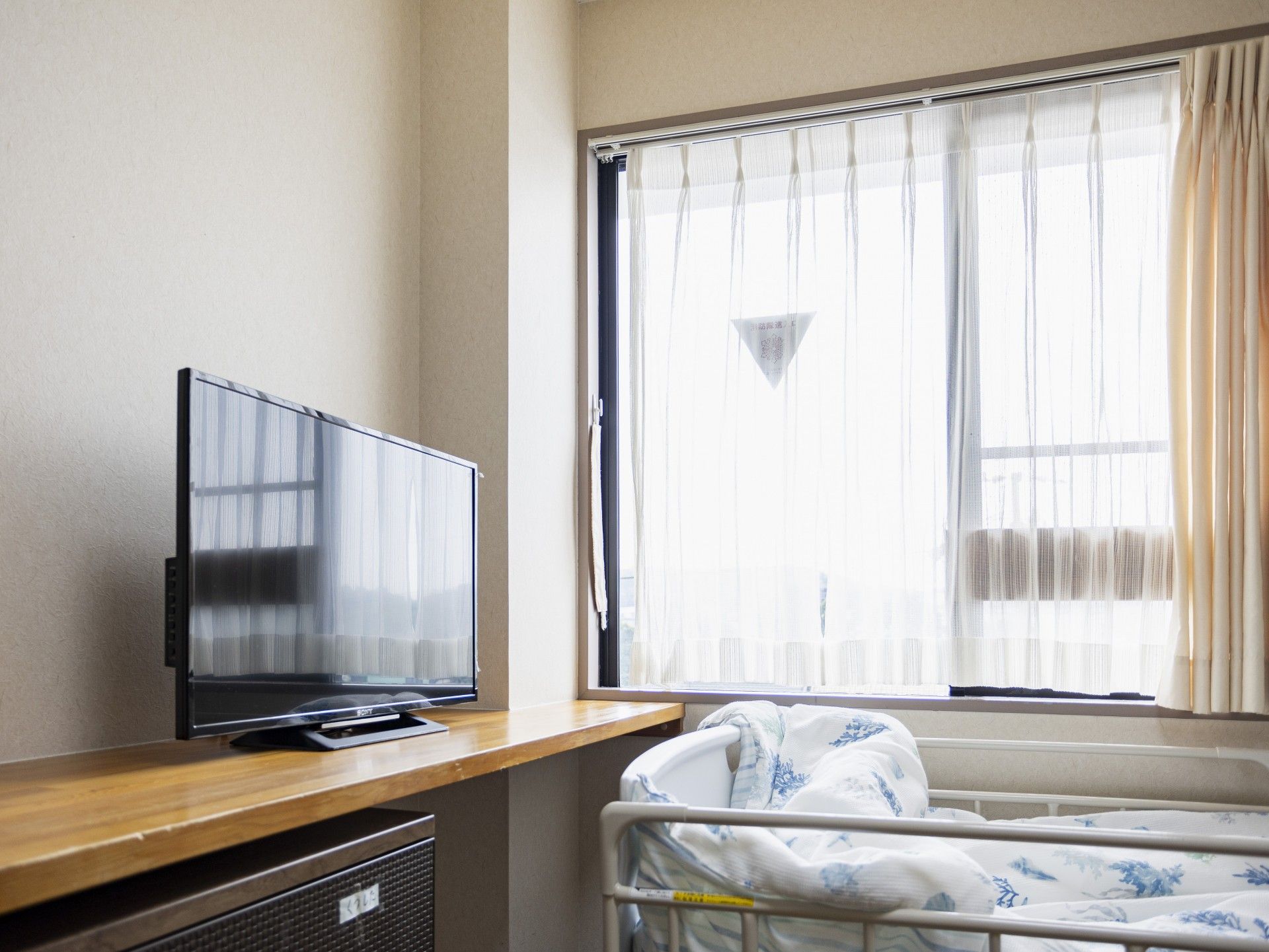 高齢者の方にタオルをかけてマッサージしているスタッフと振り返りながら会話する女性の様子