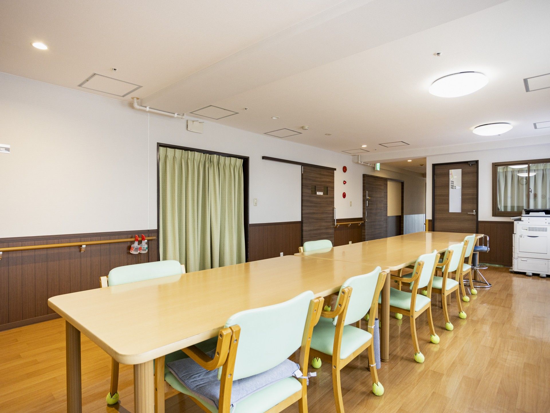 なにかを指さして笑顔で話している車いすの女性とそれを押している介護スタッフの様子