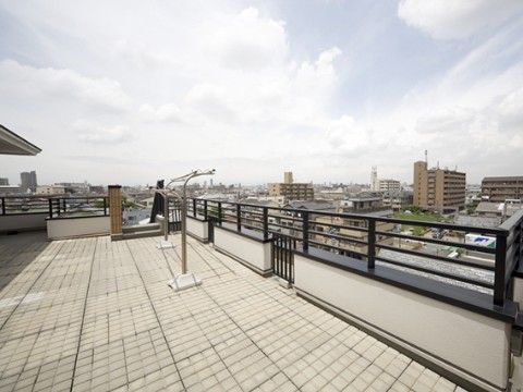 曇り空の日に物干し竿が置かれた施設屋上から見た景観