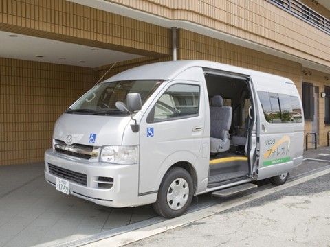 車椅子マークが貼られスライドドアに施設名称が明記された施設専用車