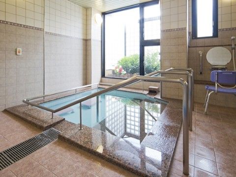 窓から外の光が差し込む明るい浴室である。浴槽では足を伸ばしてゆったりとくつろぐことができる。出入りの際には手すりがあるので安心である。