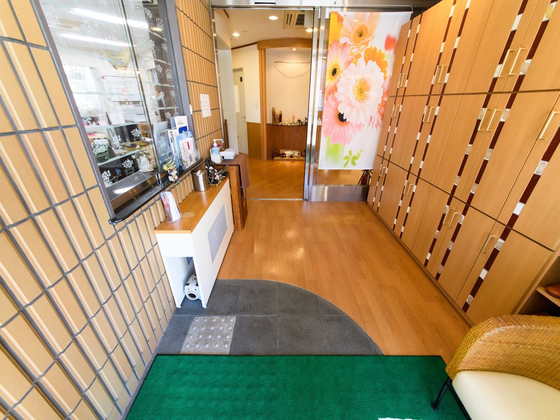 窓口があり、小冊子が置かれている。エントランスホールには和風の小物が複数飾られている。手指の消毒液が設置されている。