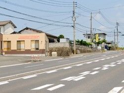 バイパス沿いにあり、車は走っていない。道路沿いには商業施設などがある。