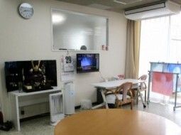 エアコンが付いた共有スペースには木製のテーブルセットやテレビがあり、大きな窓も付いている。