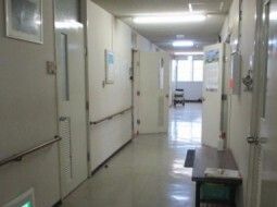 まっすぐな廊下の突き当りには窓があり、壁には手すりが付いている。居室のドアはスライド式。