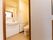 扉の奥に見える洗面台とトイレがある部屋