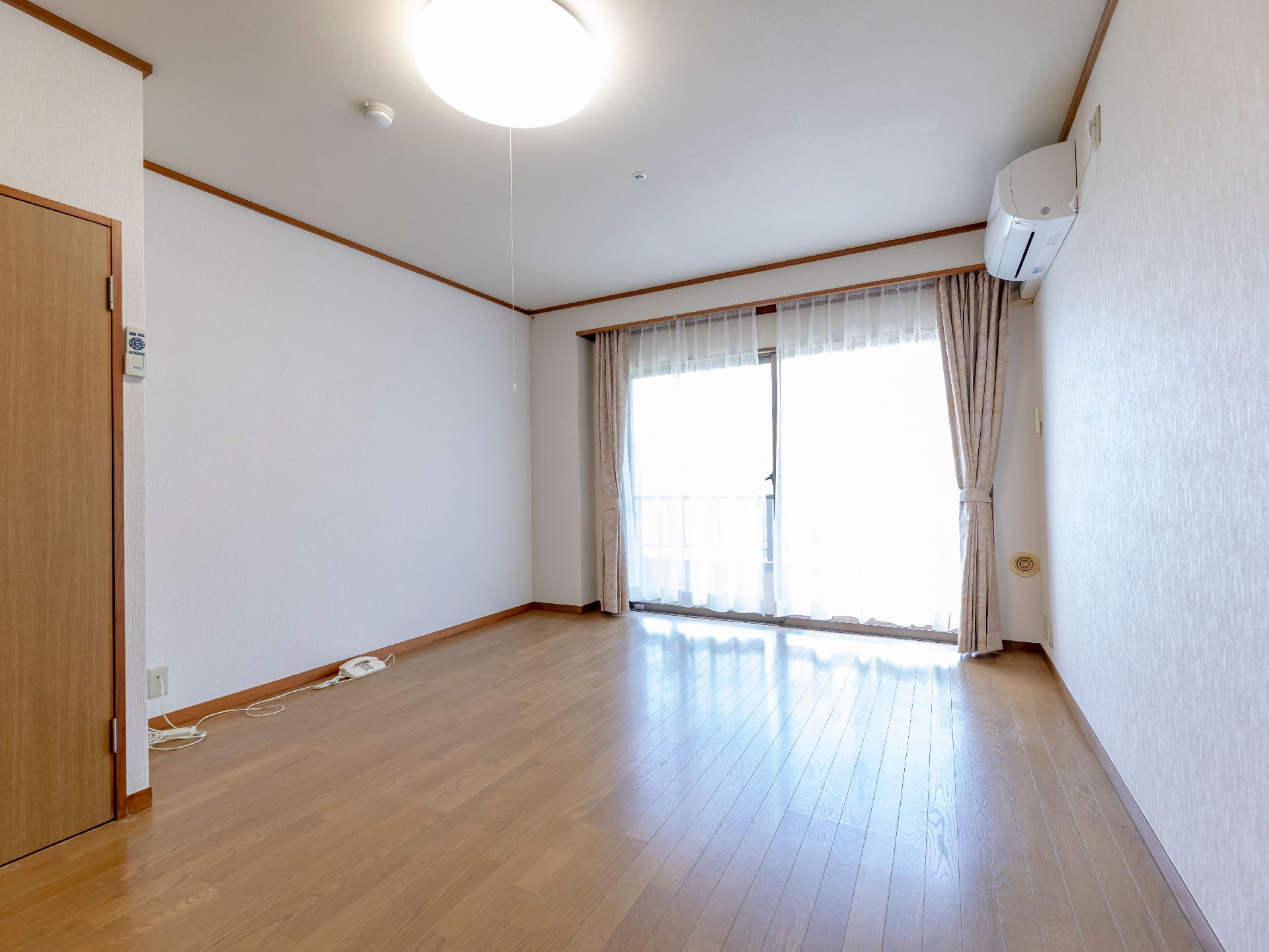 白い部屋の一面にある窓ガラスから差し込む光