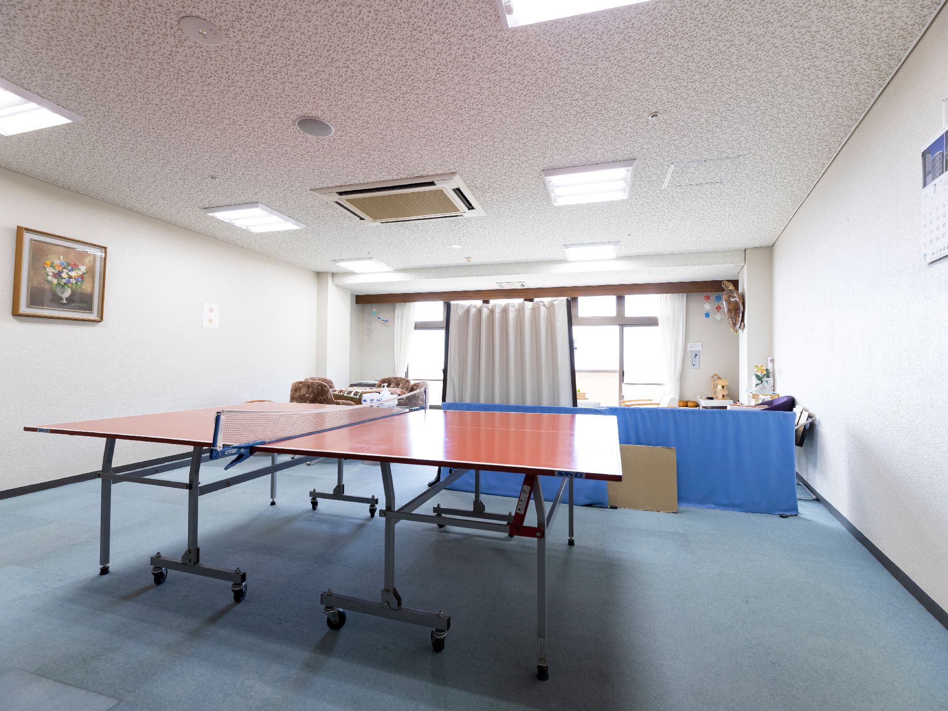 真ん中に仕切りがあり手前側に卓球台がある部屋