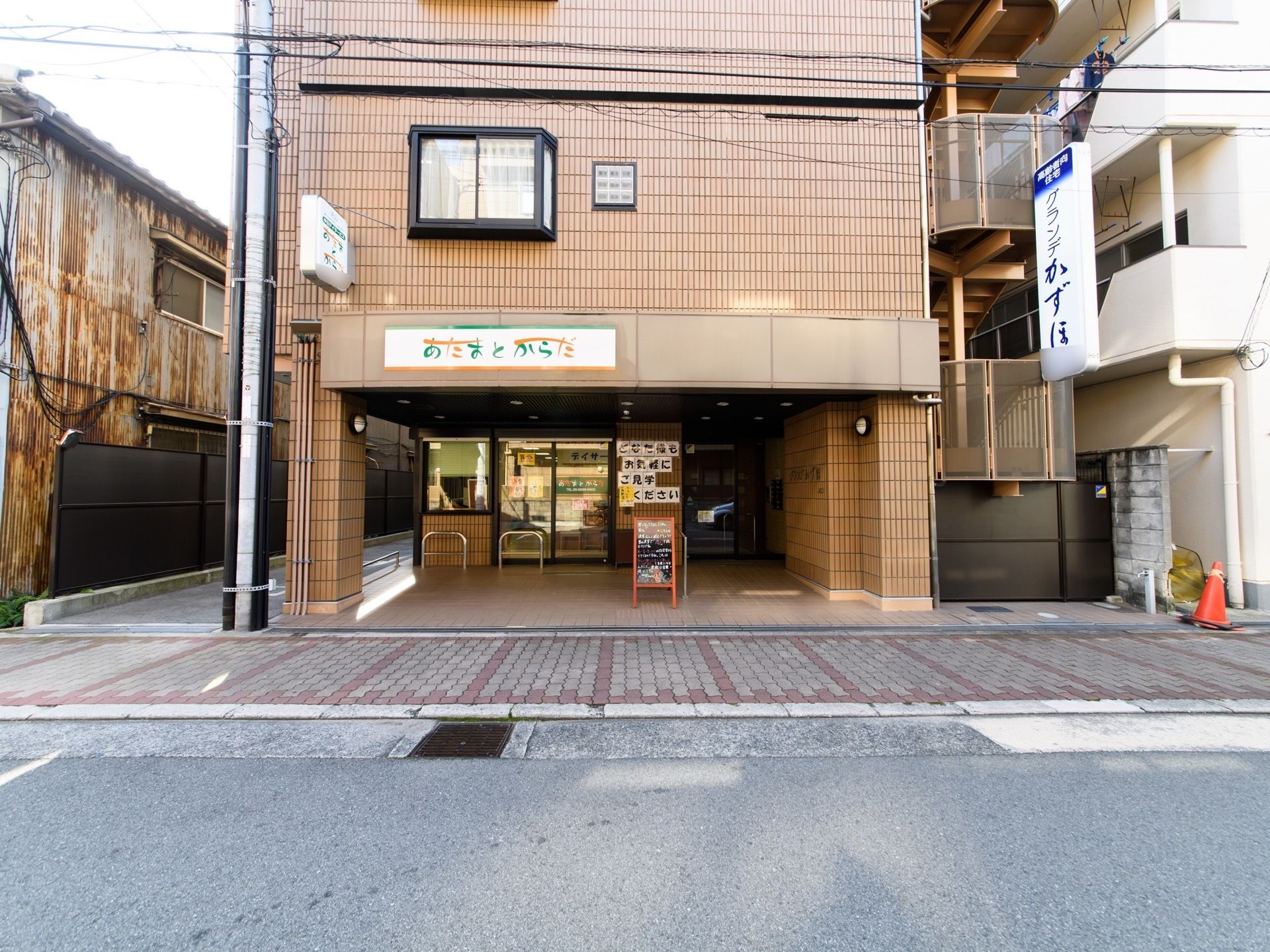 デイサービスは茶色い外観である。1階部分はガラス張りになっているので中の様子が分かるようになっている。
