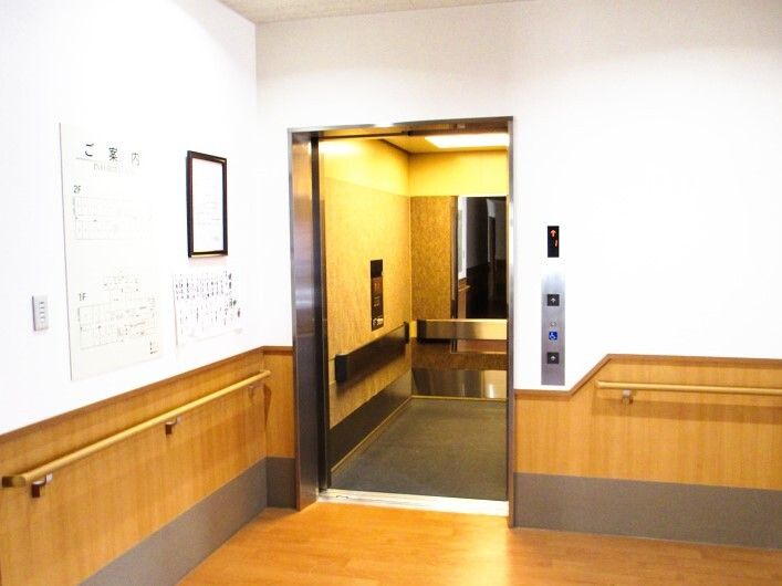 施設用の大きめのエレベーターの様子。手前に手すりがついた壁が見えている様子