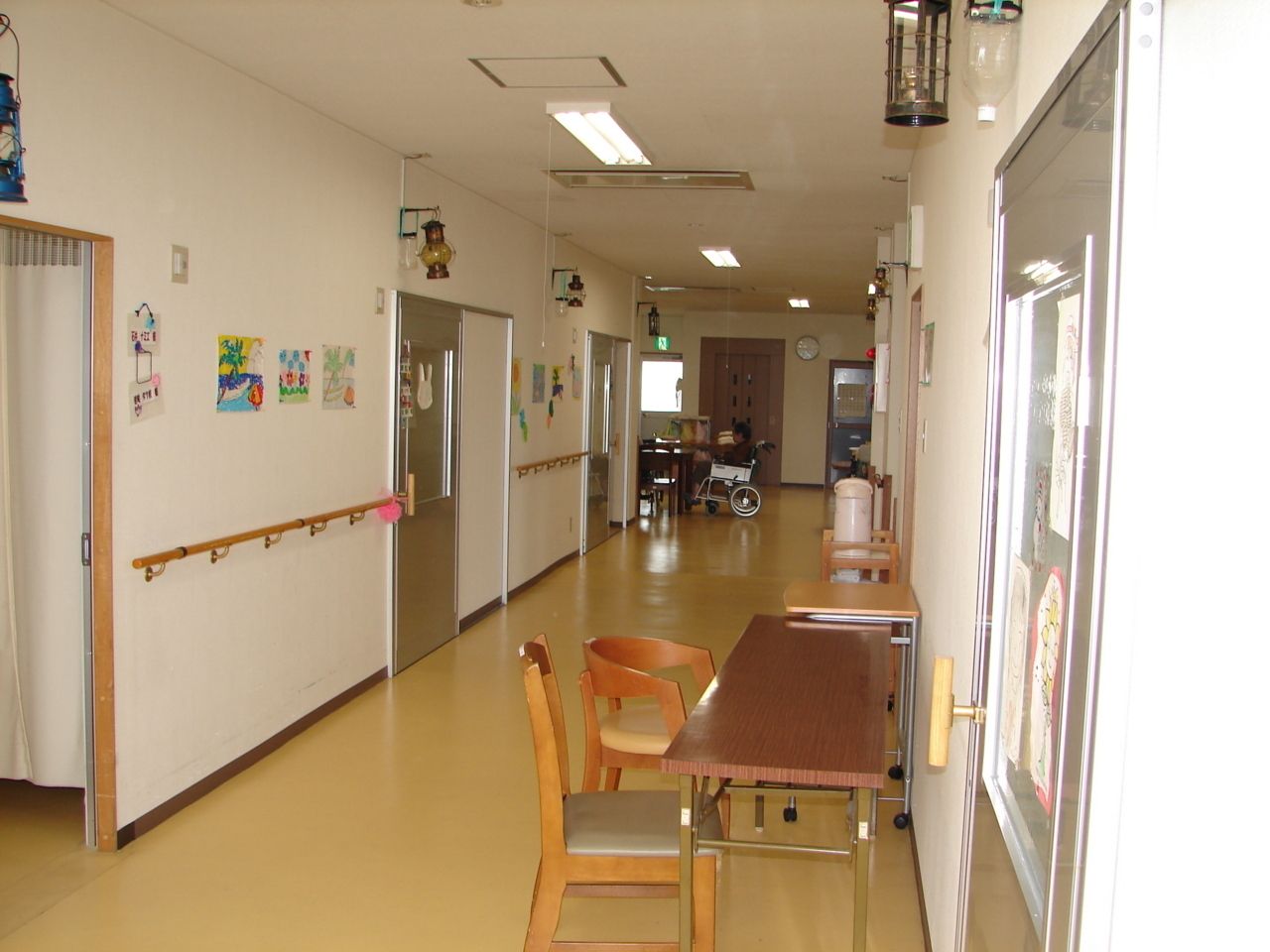 からだを動かしている高齢女性と男性スタッフの様子。施設内で体操しているときの一場面