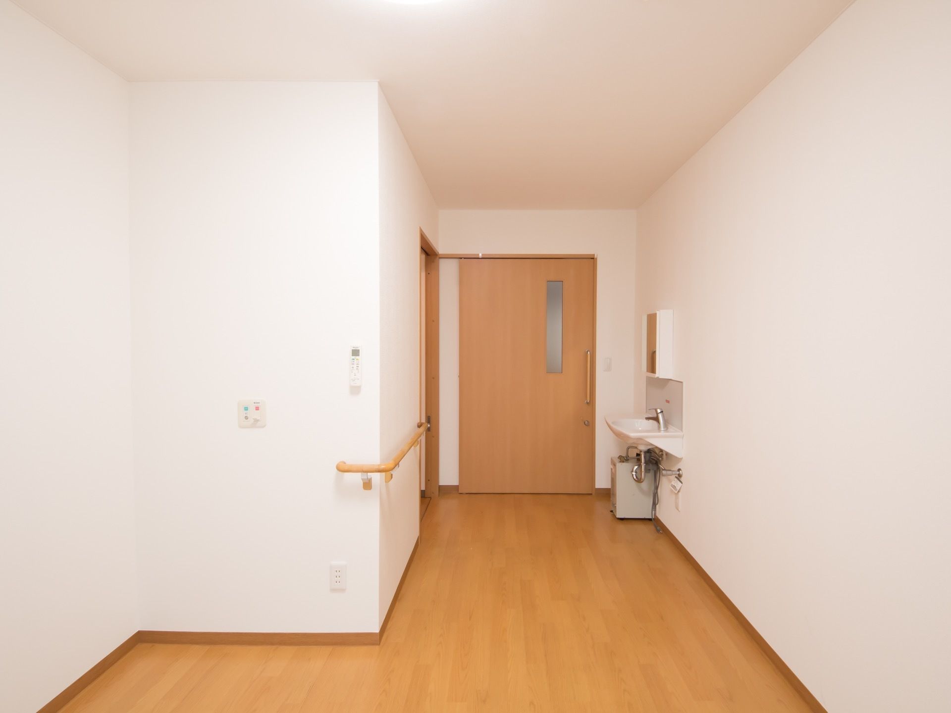 洗面台やトイレが備えつけられたシンプルな作りの居室となっている。居室内にも手すりが設置されており安心できる。