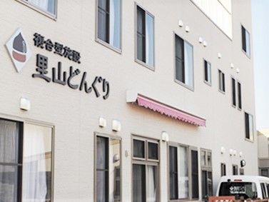 里山どんぐりの看板が掲げられている施設の様子。ホワイトを基調にした施設の外観