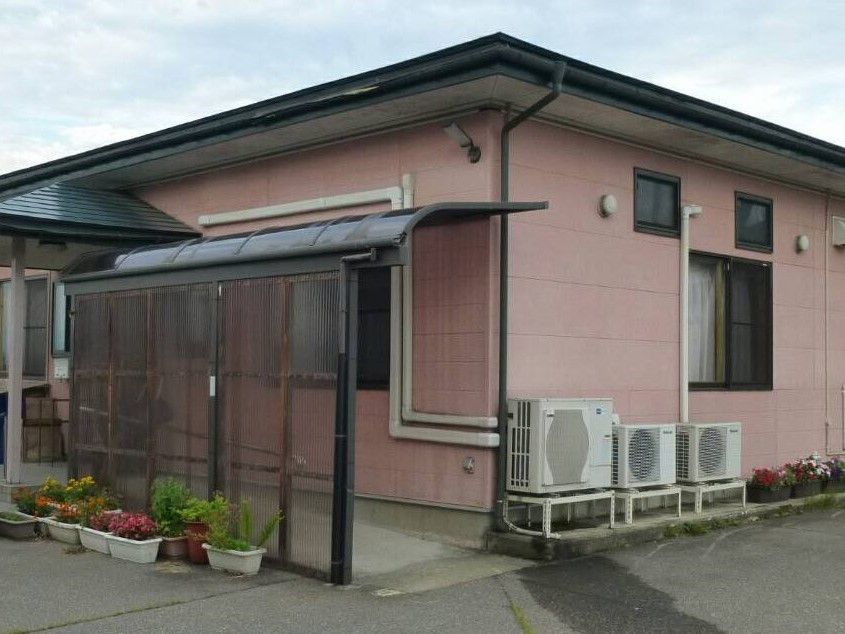 温かな色合いの外観の家。平屋建てに近い設計の建物の写真