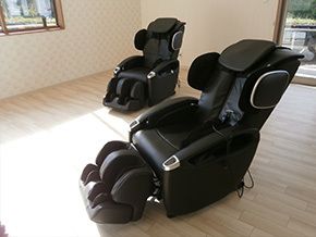 マッサージチェアは黒く、足や頭のマッサージもできるタイプ。