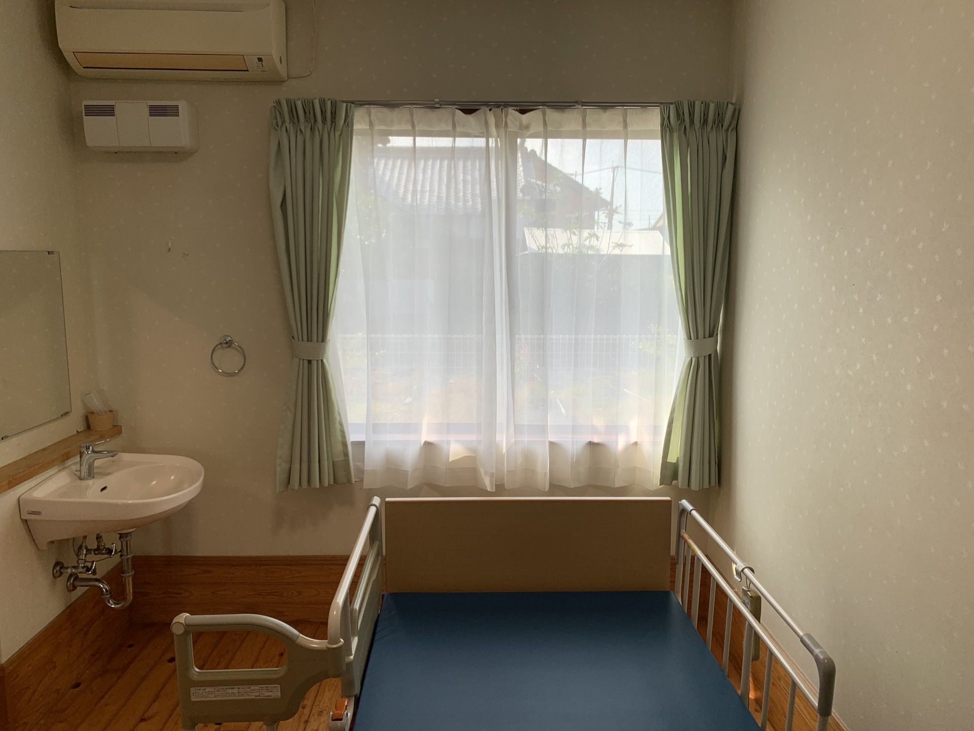 窓際のベッドと洗面台