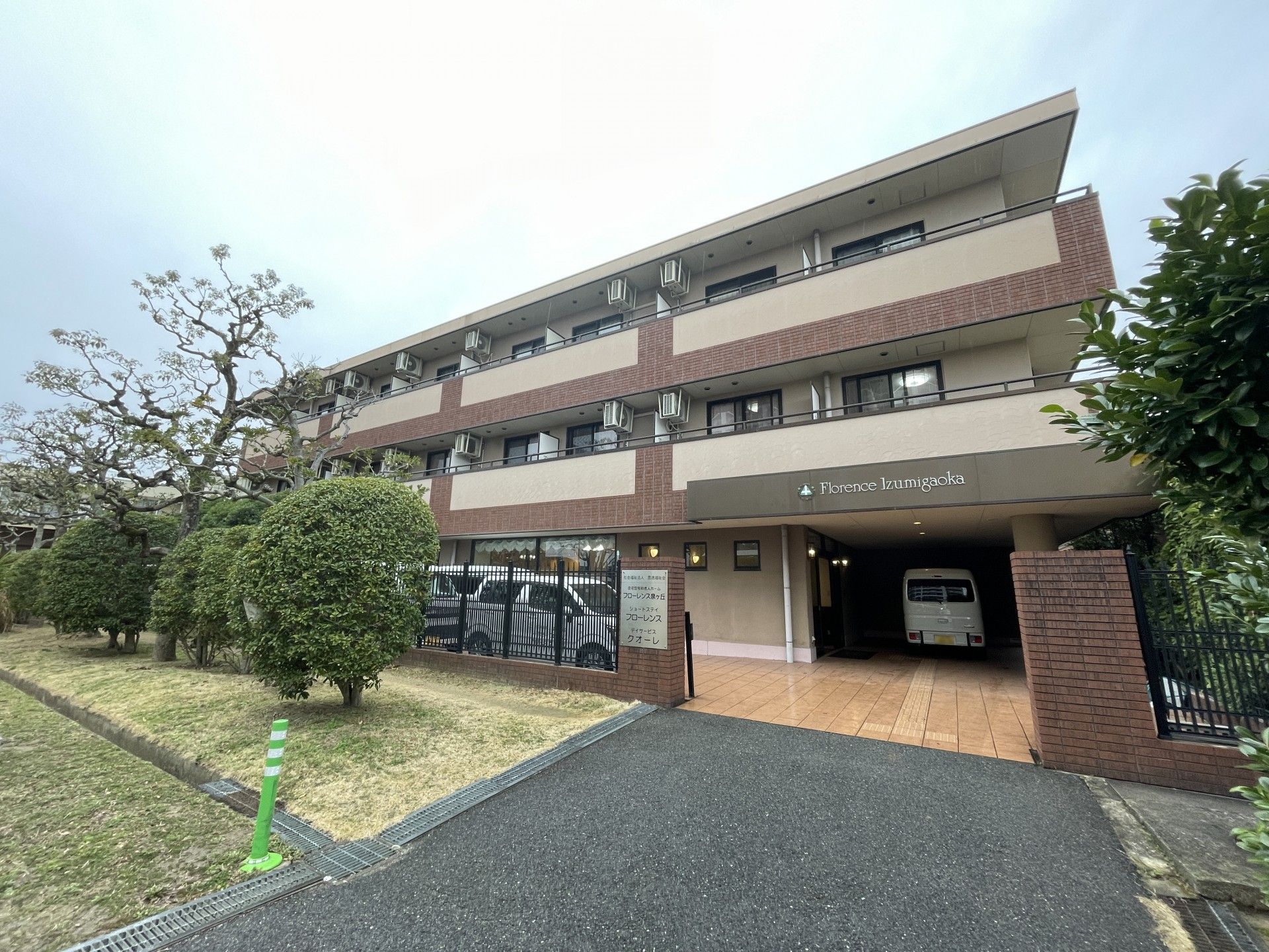 各フロアにはベランダが設置され、建物周辺には緑が植えられ、玄関にはホーム名が書かれている。