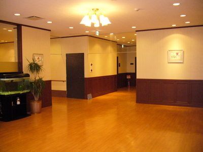 フローリングの共有スペース。魚が泳ぐ水槽や絵画、観葉植物が置かれ、温かい雰囲気。
