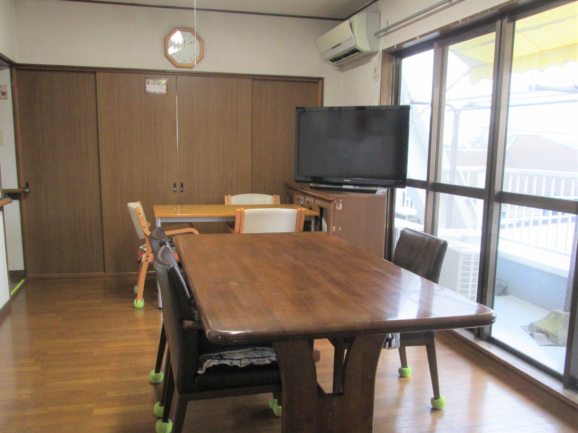医師・看護師と笑顔で話している高齢者女性。車いすに乗っている様子