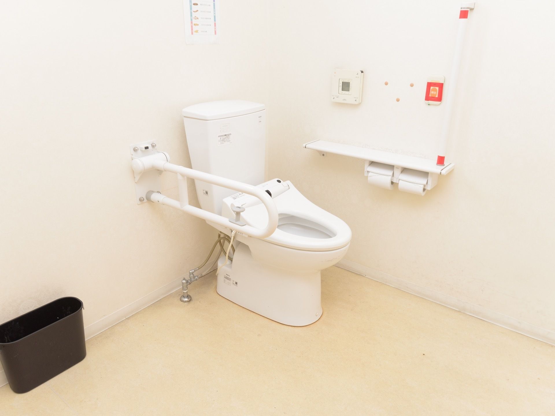 広々とした清潔感あふれるトイレである。壁にはナースコールや手すり、ペーパーホルダーが取り付けられている。