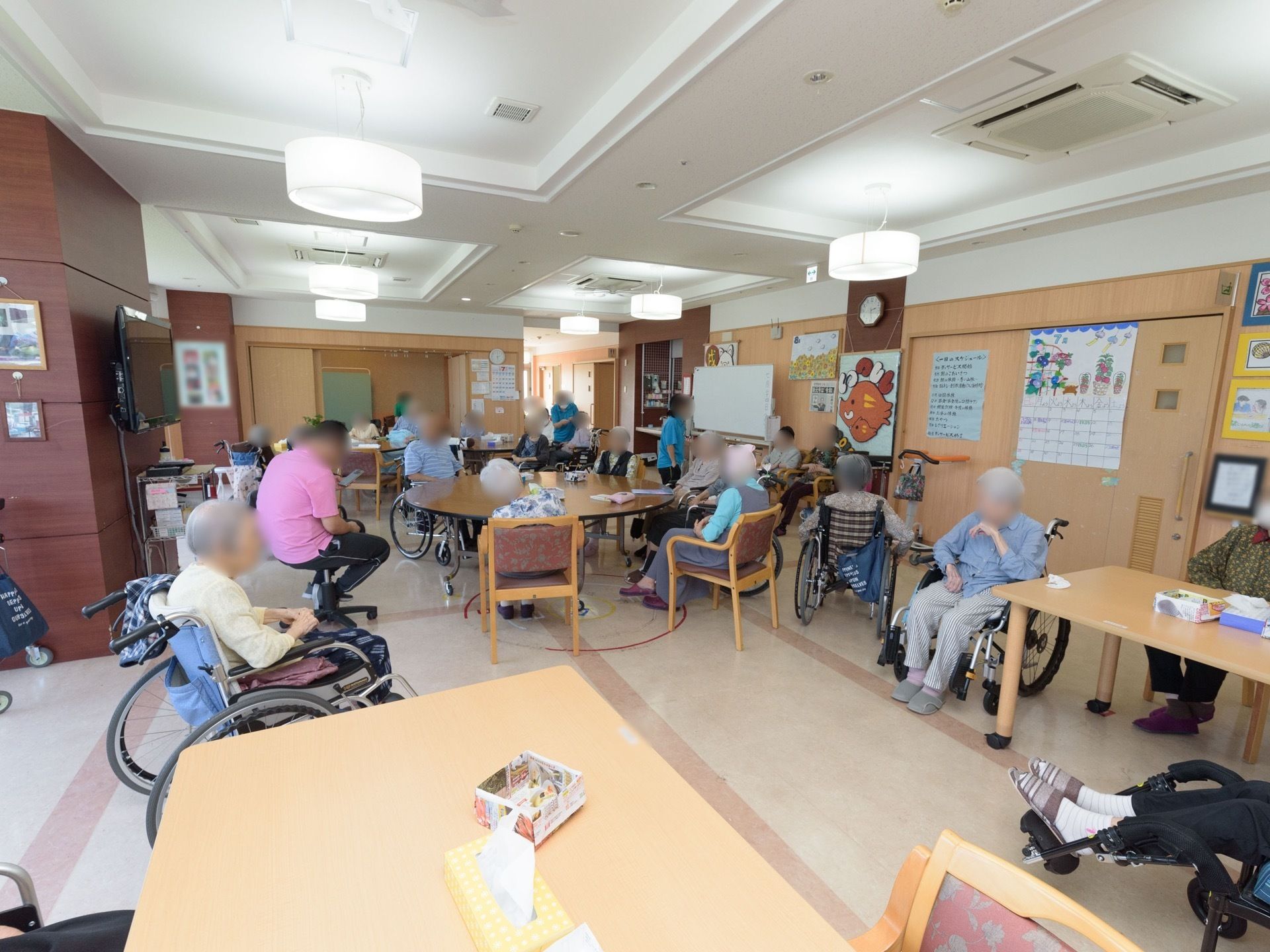 通路途中に設けられている開放的な食堂である。入居者様一人ひとりが椅子に座り、自由な時間を過ごしている。