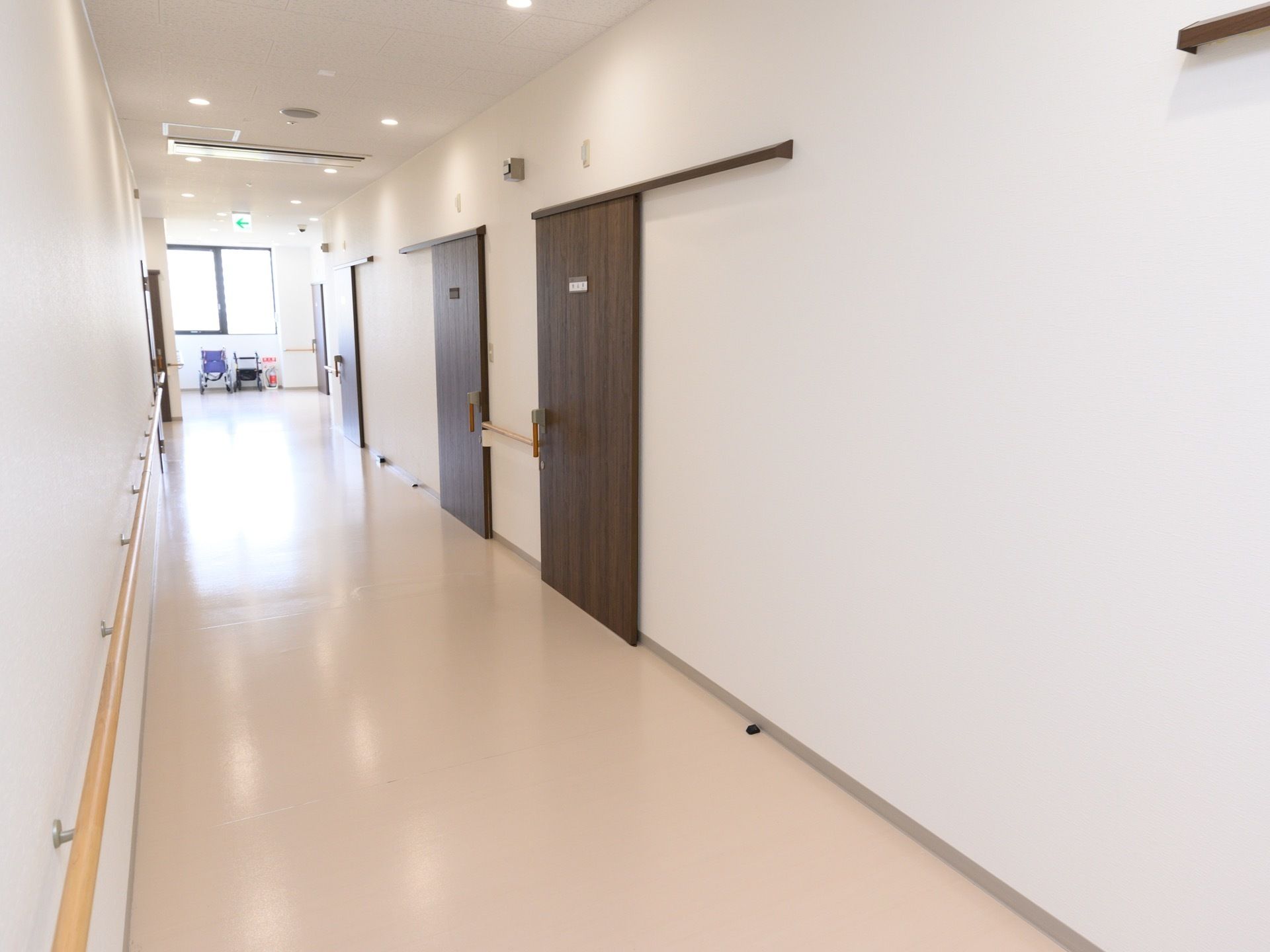 共用廊下には居室のスライドドアが並んでいる。ネームプレートが付いているので、速やかに自室を確認することができる。