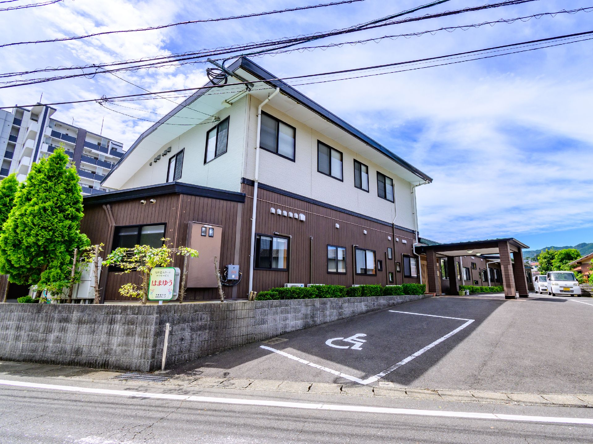 駐車場の出入り口から見た、斜め前から見た施設全体の外観
