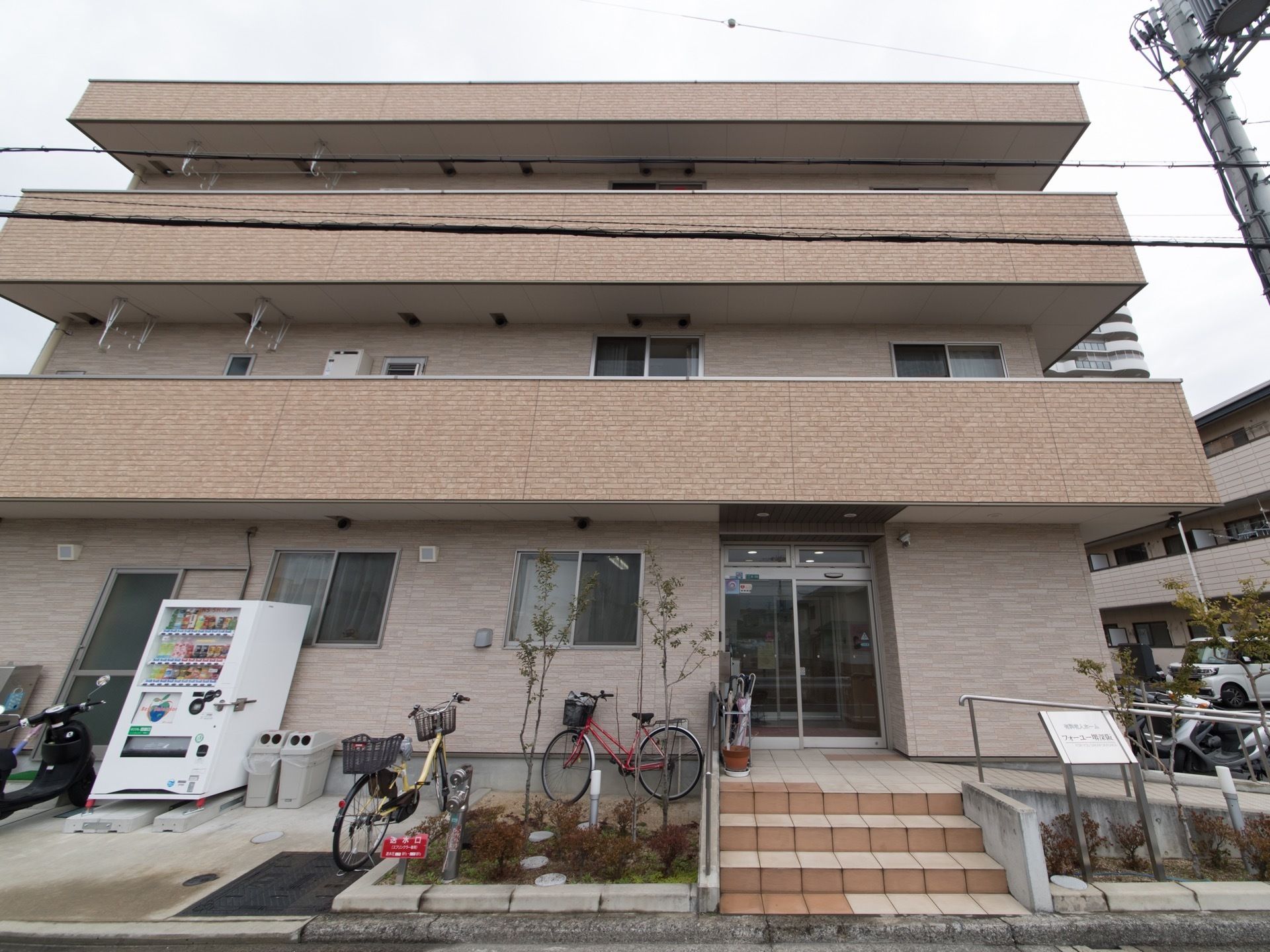 小さな煉瓦張りの建物は、ご来館いただきやすい印象となっている。入居者様のちょっとした差し入れに自動販売機も設置している。