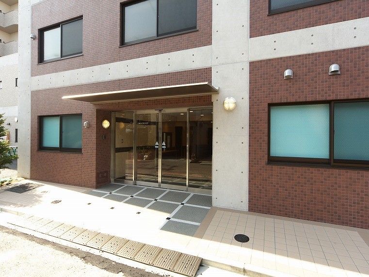 自動ドアの上には屋根が付き、玄関周辺には余計なものが置かれていない。