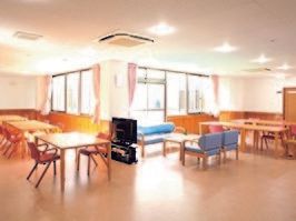 広めのリビングにテーブルと椅子、ソファなどが並んでいる様子。施設内のリラックススペースの写真