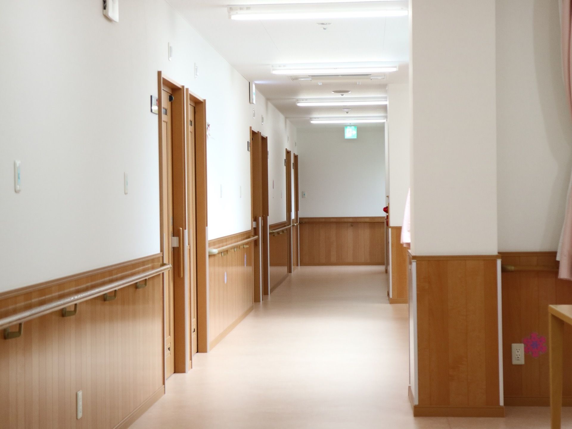 通路の壁には、木製の腰壁が廻らされており、手すりがある。右側に扉が並んでおり、正面には非常口表示灯が取り付けてある。