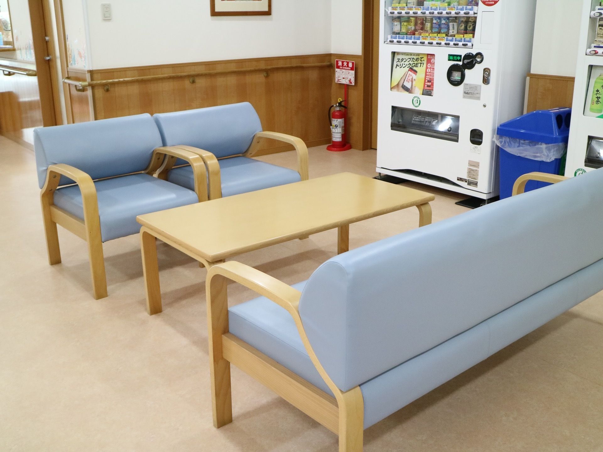 水色のビニールが施されたソファが設置されているスペース。右側に飲料の自動販売機とゴミ箱が設置されている。